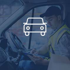 Man with yellow work vest on sitting in a semi truck using a tablet and working with ERP software for transportation